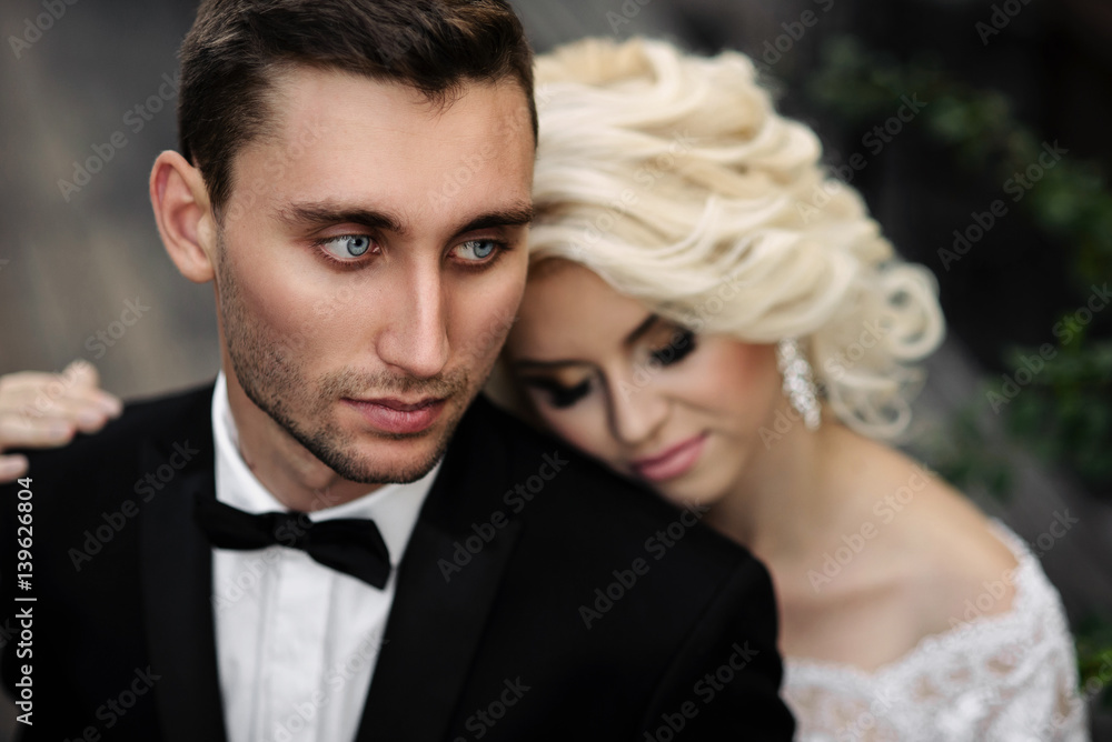 Sensual charming bride gently put her head on the shoulder of her handsome courageous groom Sensual charming bride gently put her head on the shoulder of her handsome courageous groom