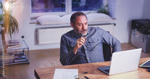 Grey Bearded mature man creative director sitting in modern office photo