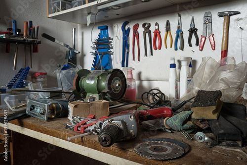 Messy workshop, complete chaos on workbench, unorganised basement or garage. Efficiency and arrangement in workshop, time to sort out mess concept.