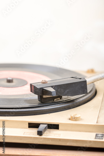 Closeup of old and dusty vinyl record player with arm and needle in focus