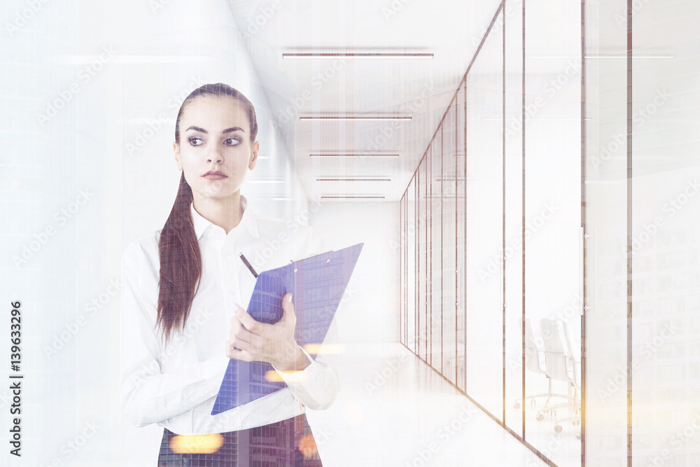 Woman with clipboard in office lobby, toned Woman with clipboard in office lobby, toned