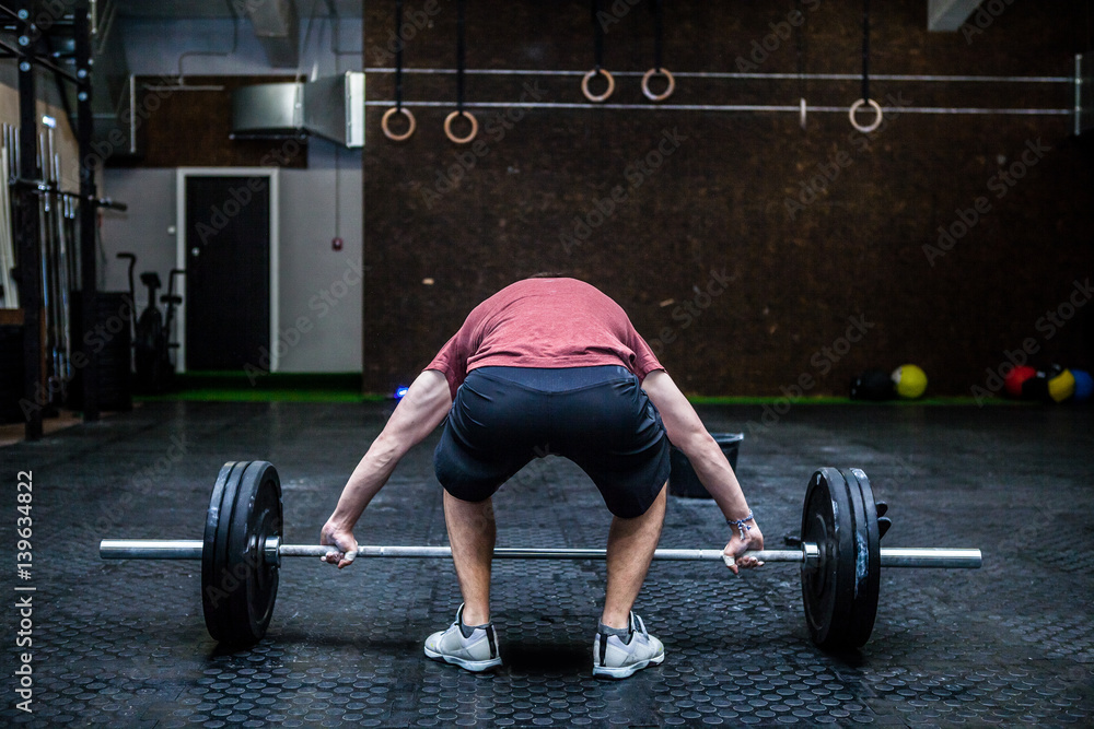 Young man with weight training equipment in sport gym Young man with weight training equipment in sport gym