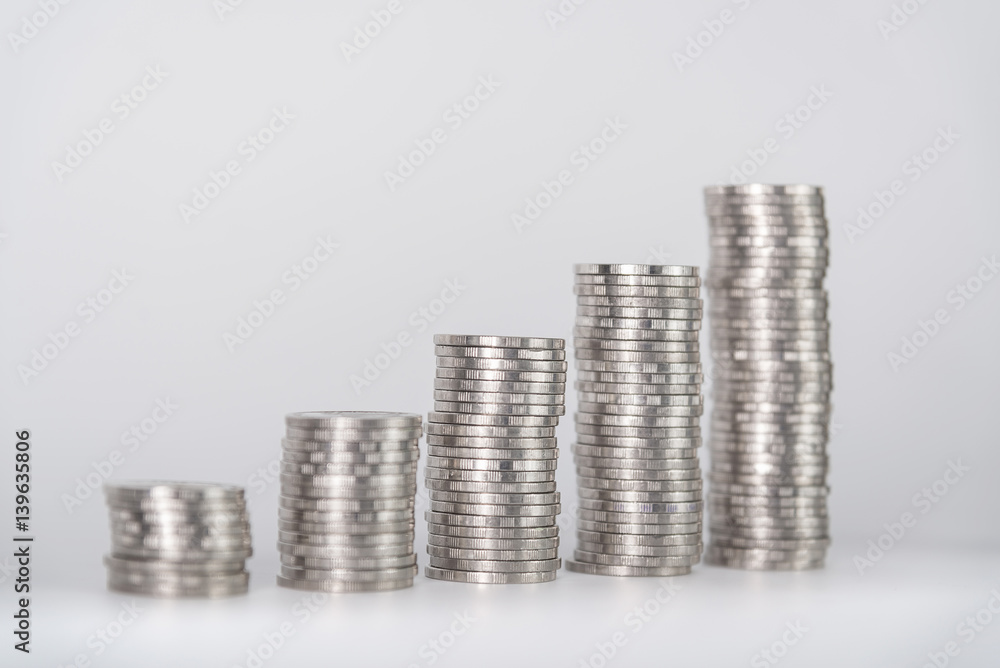 Increasing columns of coins, piles of coins arranged as a graph on white background