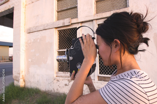 Girl Shooting 16mm Film Camera Next to Building