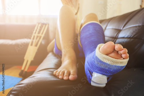 broken leg in a plaster cast with soft-focus in the background. over light