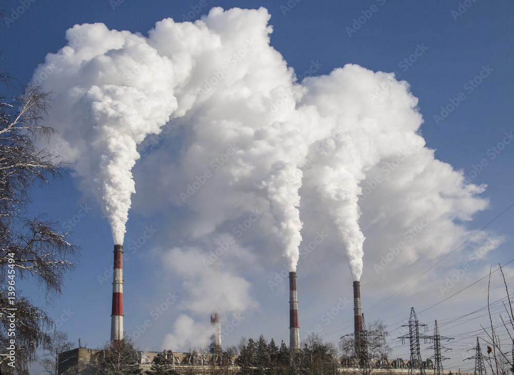 Smoking industrial chimneys. Combined heat and power. Air pollution clouds of smoke coming from the chimneys. Energy plant