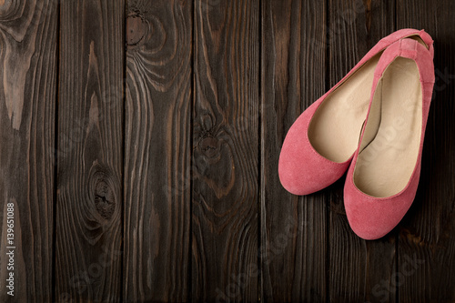 Pink women's shoes (ballerinas) on wooden background.