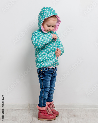 little girl fastening her blue jacket photo