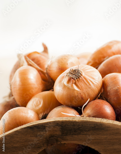 raw onion in basket and on a table