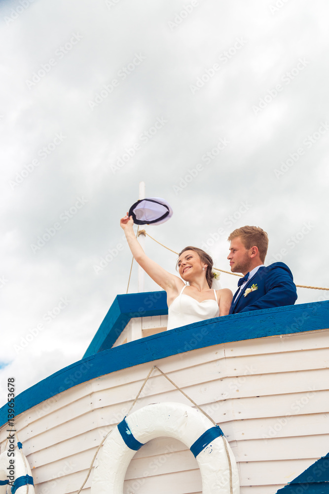 Obraz premium Wedding couple on small boat. The bride and groom on the ship