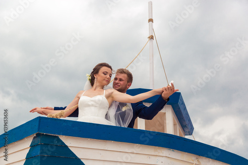 Wedding couple on small boat. The bride and groom on the ship