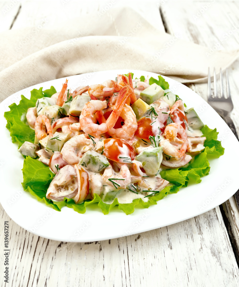 Salad with shrimp and tomatoes in white plate on board Salad with shrimp and tomatoes in white plate on board