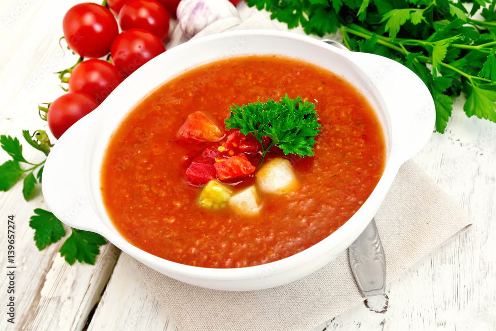 Soup tomato in white bowl with vegetables and parsley on board Soup tomato in white bowl with vegetables and parsley on board