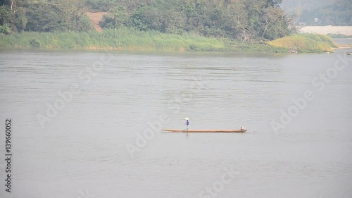 Thai and laos people riding long tail boat for catch fishing in Mekong river at Kaeng Khut Khu in Chiang Khan city at sunset time on February 21, 2017 in Loei, Thailand photo