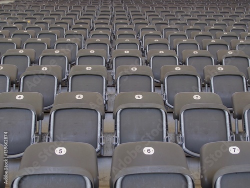 Rows of empty grey seats in an arena or stadium