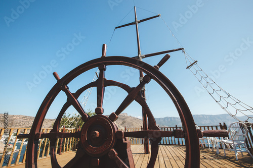 Rudder of an old wooden sailing boat. Steering wheel of a retro vintage ship