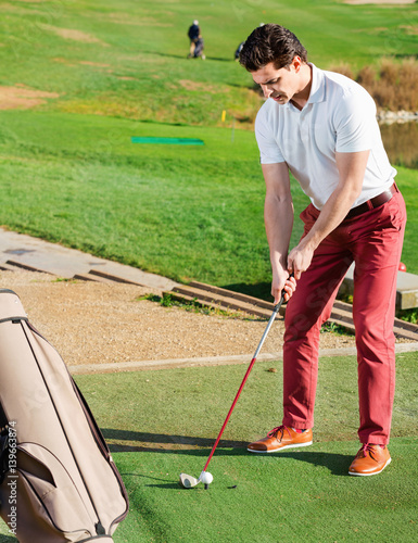 Man preparing to hit ball at golf course