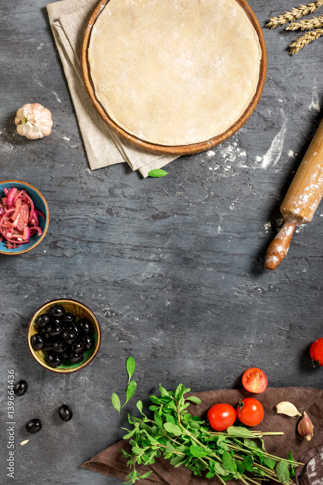 Frame of pizza dough with ingredients for cooking vegetarian pizza Frame of pizza dough with ingredients for cooking vegetarian pizza