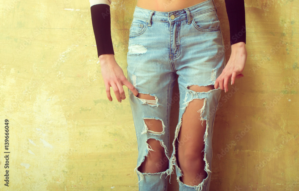 Fashion girl posing in jeans in the studio. Sexy woman wearing denim shorts  with holes. Street style fashion girl. Legs over london texture background  Stock Photo | Adobe Stock