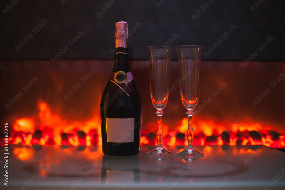 two glasses and a bottle of champagne in front of the fireplace two glasses and a bottle of champagne in front of the fireplace