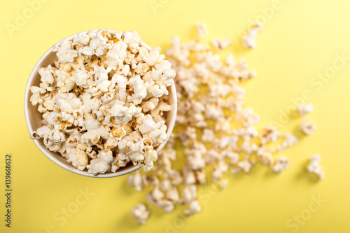 top view of popcorn in paper cup on yellow