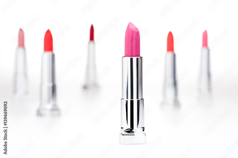 Close-up view of fashionable glossy lipstick with set of different lipsticks behind Close-up view of fashionable glossy lipstick with set of different lipsticks behind