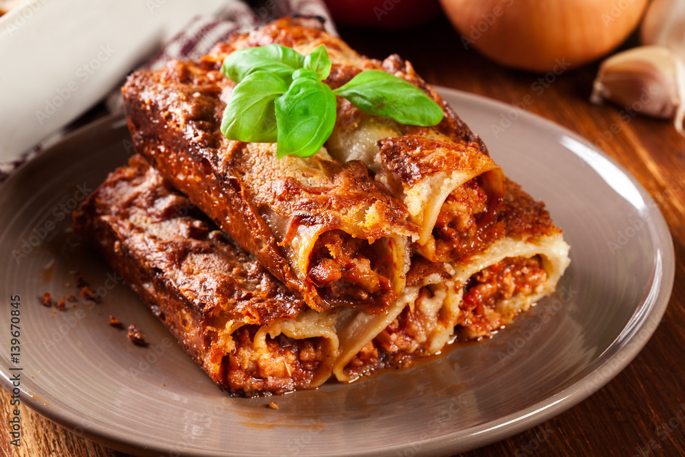 Baked cannelloni with minced meat and bechamel sauce on a plate Baked cannelloni with minced meat and bechamel sauce on a plate