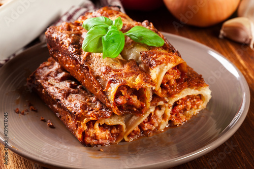 Baked cannelloni with minced meat and bechamel sauce on a plate photo