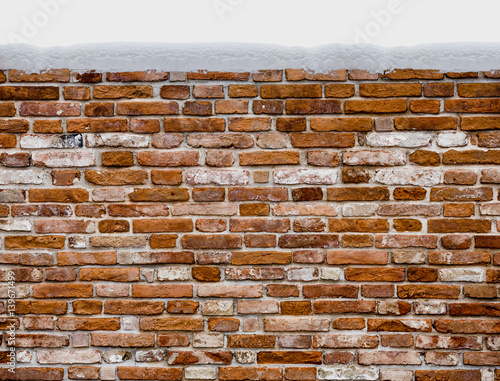 Snow covered red brick wall isolated on white