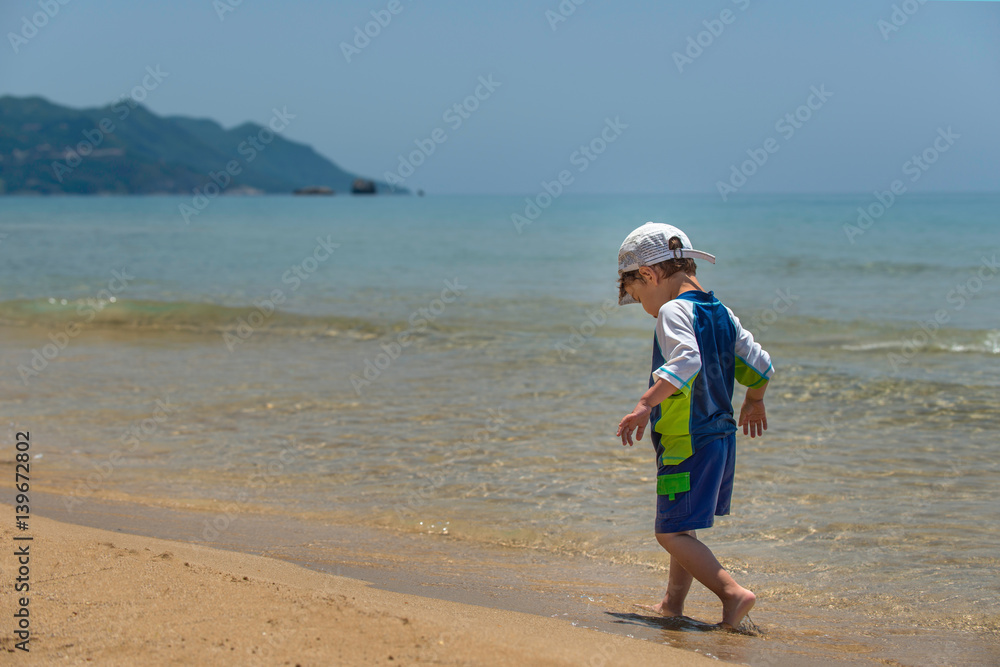 Cute little boy walking by the sea Cute little boy walking by the sea