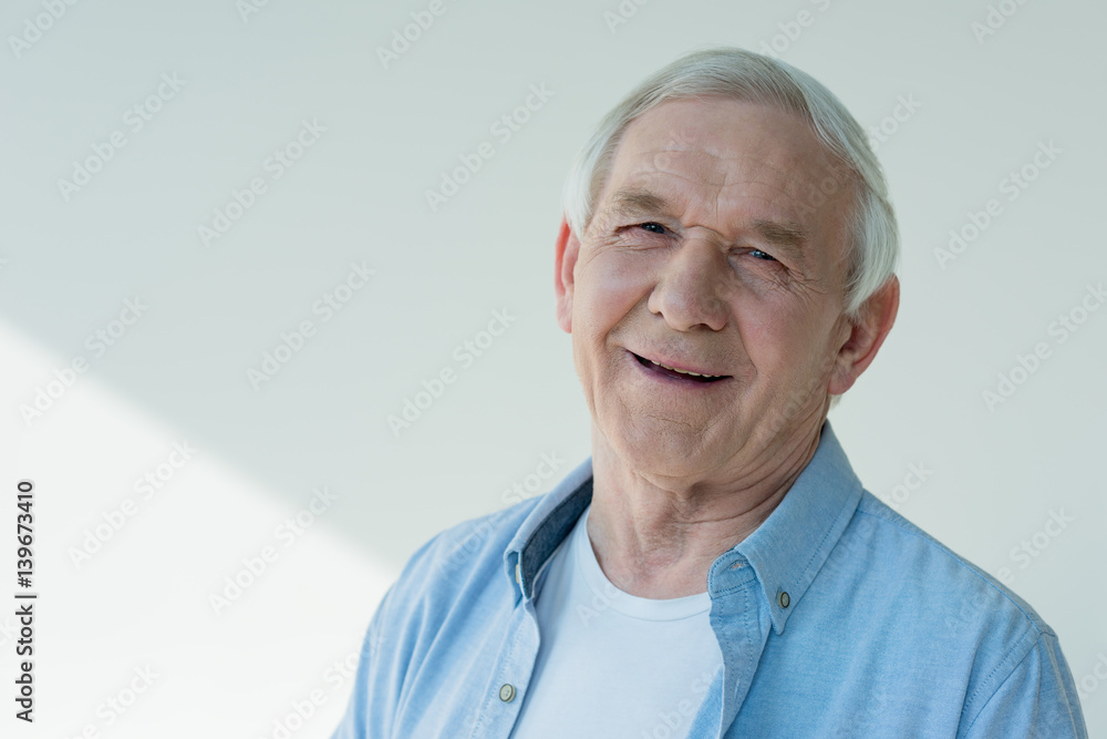 portrait of smiling senior man in casual shirt on white portrait of smiling senior man in casual shirt on white