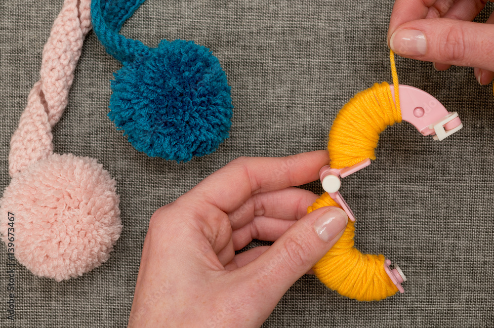 Fotografie Hands Looping Yellow Yarn Around Pom-Pom Maker