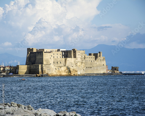Castell del Ovo (Egg Castle) in Naples, surronded by the sea, and mount vesubio can be seen in the background photo