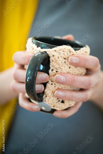 Hands Holding Mug in Crocheted Cozy