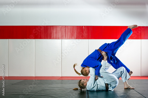 Two women fight judo on tatami photo
