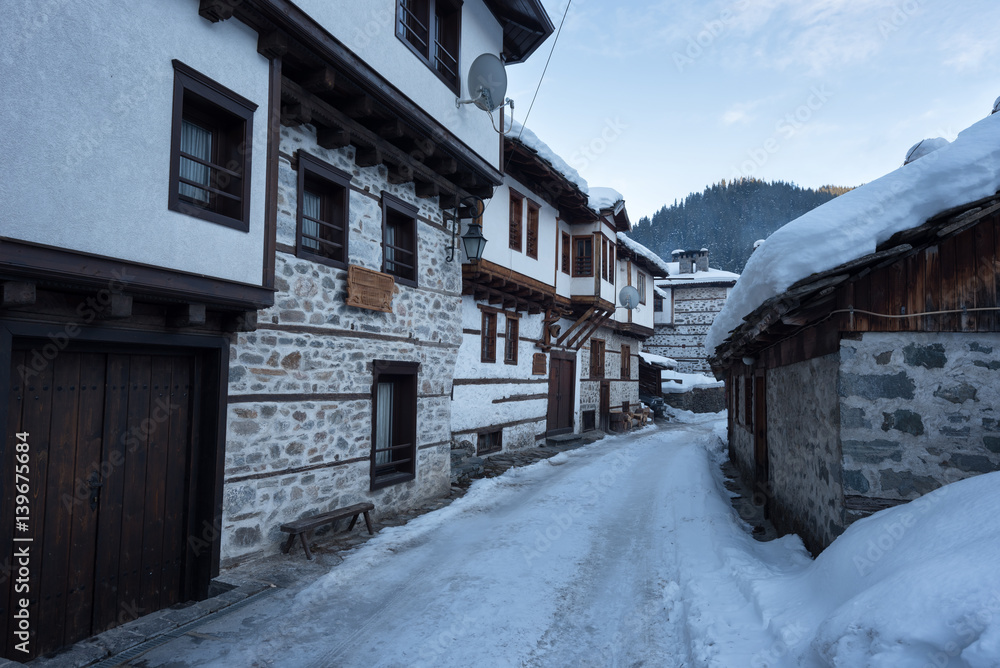 Winter scene. Along the narrow streets of Shiroka Laka village, Bulgaria in a sunny winter day Winter scene. Along the narrow streets of Shiroka Laka village, Bulgaria in a sunny winter day