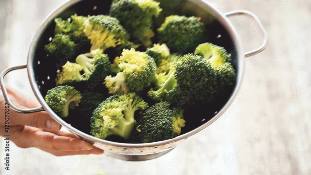 Fresh broccoli in stainless steel colander on old wooden background Fresh broccoli in stainless steel colander on old wooden background