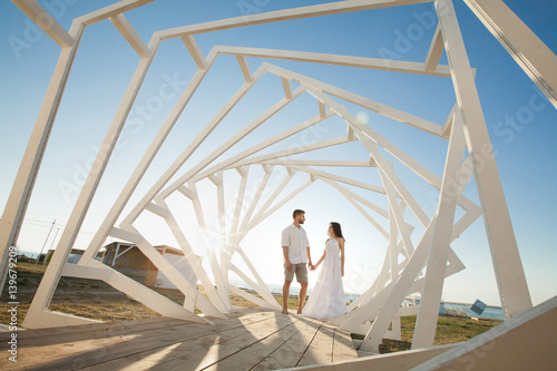 Man and woman posing. Geometric wooden structures. The bride and groom. © Artem Zakharov