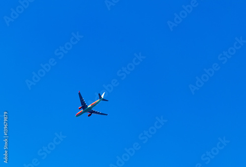  Aircraft is flying in blue cloudy sky over the sea.