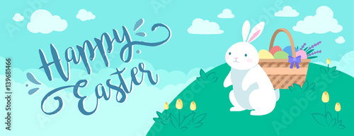 Happy Easter greeting banner with the white rabbit and the basket of eggs on the lawn on the background with blue sky and clouds.	