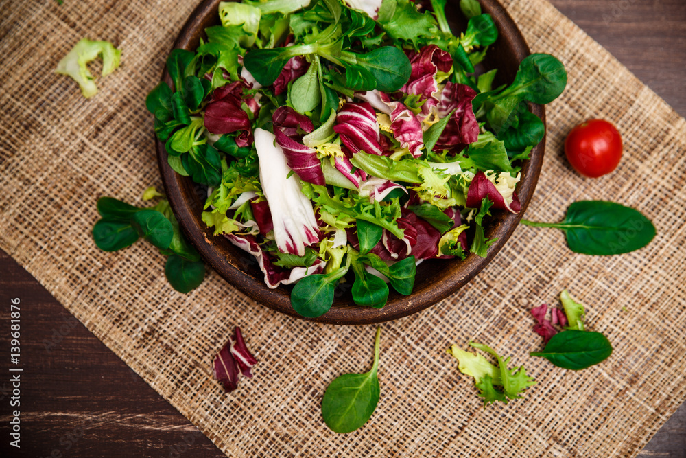 Provence salad. Leaves of endive or chicory, lamb and rose salad. Cherry tomato. Raw vegetables. On wooden table. Provence salad. Leaves of endive or chicory, lamb and rose salad. Cherry tomato. Raw vegetables. On wooden table.