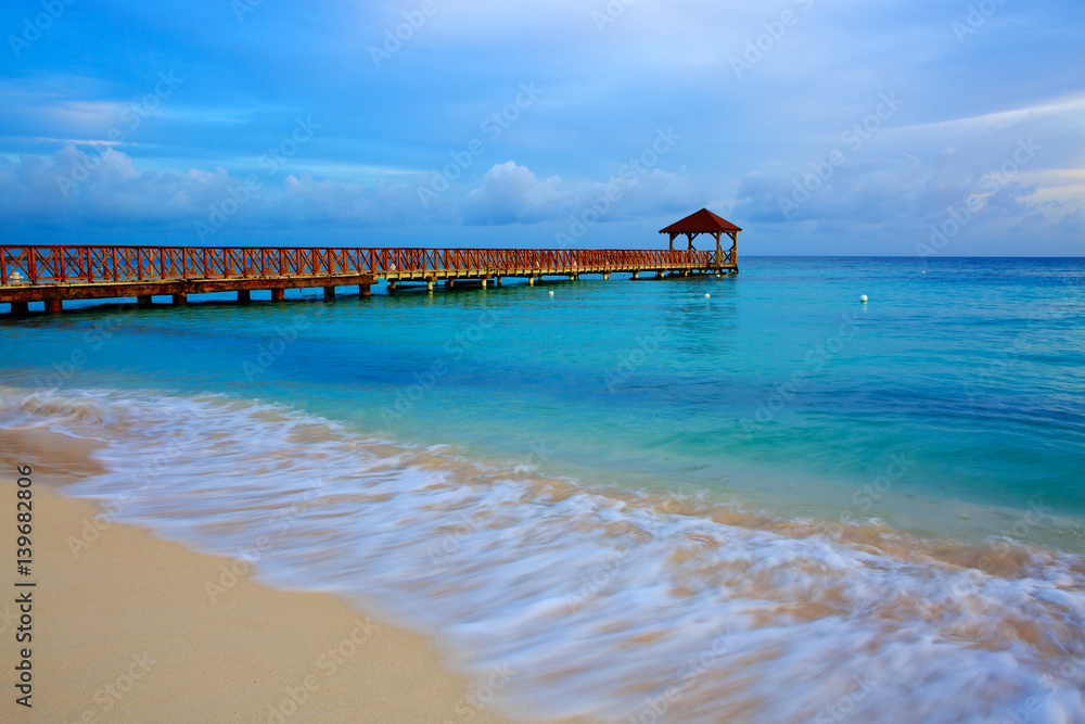 Beach of caribbean sea and wooden pier .