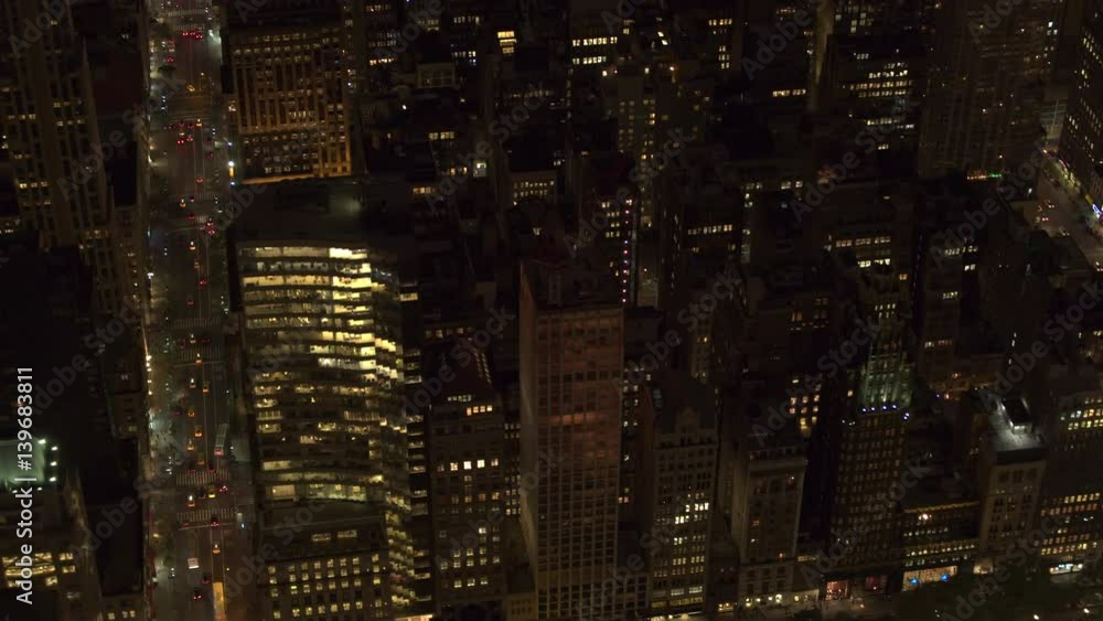 AERIAL HELI SHOT: Rush hour on busy 5th avenue in city that never sleeps after the sunset. Cars commuting and yellow cabs traveling along the jammed New York streets in Midtown Manhattan at night AERIAL HELI SHOT: Rush hour on busy 5th avenue in city that never sleeps after the sunset. Cars commuting and yellow cabs traveling along the jammed New York streets in Midtown Manhattan at night
