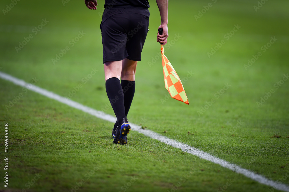 Obraz premium Assistant referee moving along the sideline during a soccer match