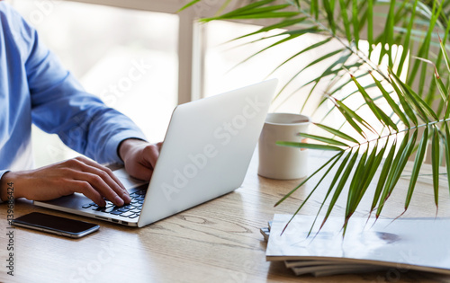 Professional at work. Top view ofman working on laptop while sitting at his working place photo