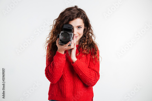 Portrait of a casual woman using retro video camera in studio