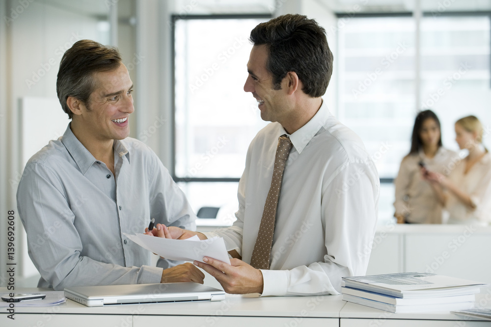 Executives discussing documents Executives discussing documents