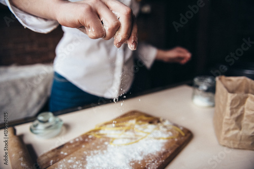 A girl in the kitchen prepares a dough