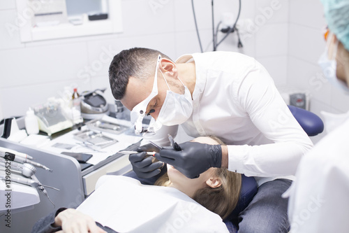 Dental cure. Molar treatment. Young female patient visiting dentist office. 