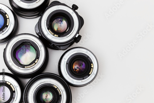 a lot of expensive photo lenses with for camera colorful reflection as a background